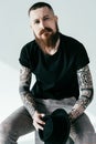 handsome bearded tattooed man looking at camera