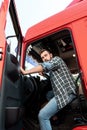 Handsome bearded truck driver inside his red cargo truck Royalty Free Stock Photo
