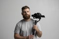 Handsome bearded videographer making a good footage using steadicam. Cameraman creator with a stabilizer in his hands Royalty Free Stock Photo