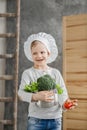 Handsome beautiful boy holding a pot full of vegetables. Healthy food. Harvest. Little chef