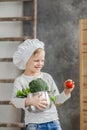 Handsome beautiful boy holding a pot full of vegetables. Healthy food. Harvest. Little chef