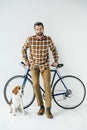 handsome bicycler standing with beagle and looking at camera