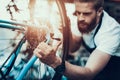 Handsome Bike Mechanic Repair Bicycle in Workshop