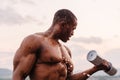 Handsome black african american muscular man lifting dumbbells against the sunset sky background Royalty Free Stock Photo