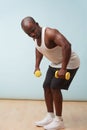 Handsome black man doing bent-over dumbbell rows. pale blue background Royalty Free Stock Photo