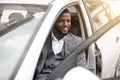 Handsome black businessman in expensive suit getting in car Royalty Free Stock Photo