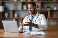 Handsome black doctor working online, having video chat at clinic Royalty Free Stock Photo