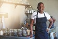 Handsome black entrepreneur stands by cafe counter