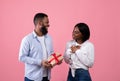 Handsome black guy giving gift box to his beloved woman, congratulating her with birthday, Valentine's Day, anniversary Royalty Free Stock Photo