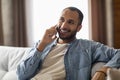 Handsome Black Guy Talking On Cellphone While Sitting On Couch At Home Royalty Free Stock Photo