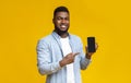 Handsome black man demonstrating cellphone with black screen