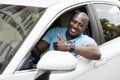 Handsome black man driving car, showing thumb up Royalty Free Stock Photo