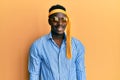 Handsome black man drunk wearing tie over head and sunglasses smiling looking to the side and staring away thinking Royalty Free Stock Photo