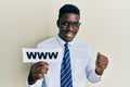 Handsome black man holding www on paper screaming proud, celebrating victory and success very excited with raised arm Royalty Free Stock Photo