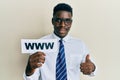 Handsome black man holding www on paper smiling happy and positive, thumb up doing excellent and approval sign Royalty Free Stock Photo