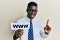 Handsome black man holding www on paper smiling with an idea or question pointing finger with happy face, number one Royalty Free Stock Photo