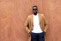 Handsome black man leaning against a wall posing serious