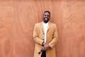 Handsome black man leaning against a wall smiling Royalty Free Stock Photo