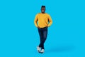 Handsome black man standing with hands in pockets over blue background Royalty Free Stock Photo