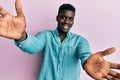 Handsome black man wearing casual clothes looking at the camera smiling with open arms for hug Royalty Free Stock Photo