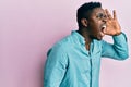 Handsome black man wearing casual clothes shouting and screaming loud to side with hand on mouth Royalty Free Stock Photo