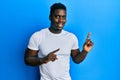 Handsome black man wearing casual white t shirt smiling and looking at the camera pointing with two hands and fingers to the side Royalty Free Stock Photo