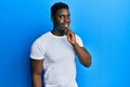 Handsome black man wearing casual white t shirt smiling looking confident at the camera with crossed arms and hand on chin Royalty Free Stock Photo