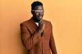 Handsome black man wearing elegant clothes and glasses smiling looking confident at the camera with crossed arms and hand on chin Royalty Free Stock Photo