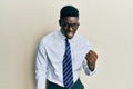 Handsome black man wearing glasses business shirt and tie angry and mad raising fist frustrated and furious while shouting with Royalty Free Stock Photo