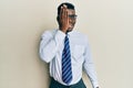 Handsome black man wearing glasses business shirt and tie covering one eye with hand, confident smile on face and surprise emotion Royalty Free Stock Photo