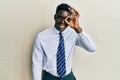 Handsome black man wearing glasses business shirt and tie doing ok gesture with hand smiling, eye looking through fingers with Royalty Free Stock Photo