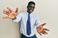 Handsome black man wearing glasses business shirt and tie looking at the camera smiling with open arms for hug Royalty Free Stock Photo