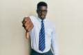 Handsome black man wearing glasses business shirt and tie looking unhappy and angry showing rejection and negative with thumbs Royalty Free Stock Photo