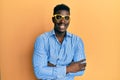 Handsome black man wearing yellow glasses happy face smiling with crossed arms looking at the camera Royalty Free Stock Photo