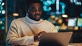 Handsome Black Project Manager Making a Video Call on Laptop Computer in an Evening Office Royalty Free Stock Photo
