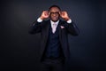 Handsome black successful and rich american businessman in dark suit. Studio fashion shot isolated on black background. Royalty Free Stock Photo