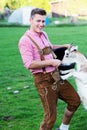 Blond bavarian man feeding a goat Royalty Free Stock Photo