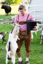Blond bavarian man feeding a goat Royalty Free Stock Photo