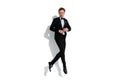 Handsome blond businessman arranging his tux while jumping