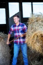 Blond man at a barn holdiing pitchfork with hay Royalty Free Stock Photo