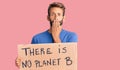Handsome blond man with beard holding there is no planet b banner covering mouth with hand, shocked and afraid for mistake Royalty Free Stock Photo