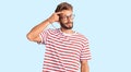 Handsome blond man with beard wearing casual clothes and glasses pointing unhappy to pimple on forehead, ugly infection of Royalty Free Stock Photo