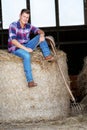Blond man in jeans sitting on haystack Royalty Free Stock Photo