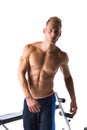 Handsome blond muscular young man next to gym bench Royalty Free Stock Photo