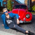 Handsome blond young man in blue sunglasses, sitting in front of Royalty Free Stock Photo
