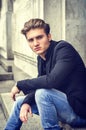 Attractive blue eyed, blond young man sitting on stair steps Royalty Free Stock Photo