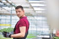 Handsome botanist carrying plants in wooden crates