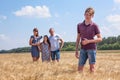 Handsome boy full length portrait with his father and preteen sister on background, Caucasian family in wheat field