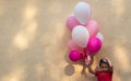 A handsome boy holds in his hand many colored balloons