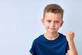 handsome boy looks angry. child is offended, threatens, shows a fist. isolated on white Royalty Free Stock Photo